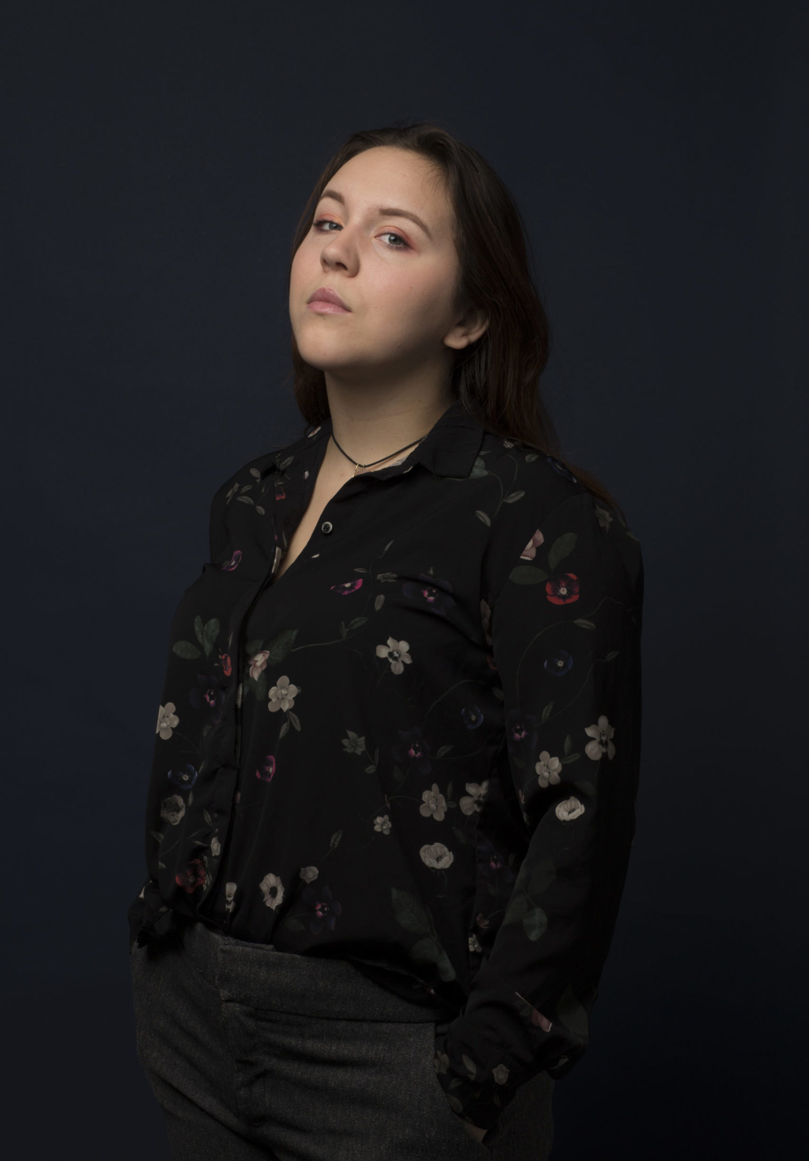 portrait of Constance in a floral shirt against a dark background